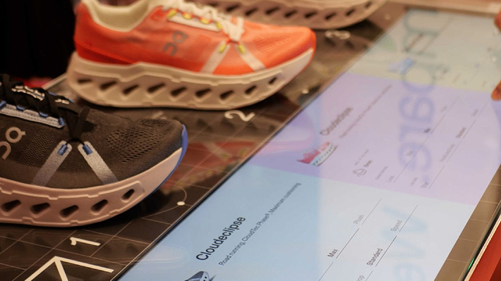 On shoes placed on the Hybrid Explorer table, with the interactive screen displaying product details and comparison data